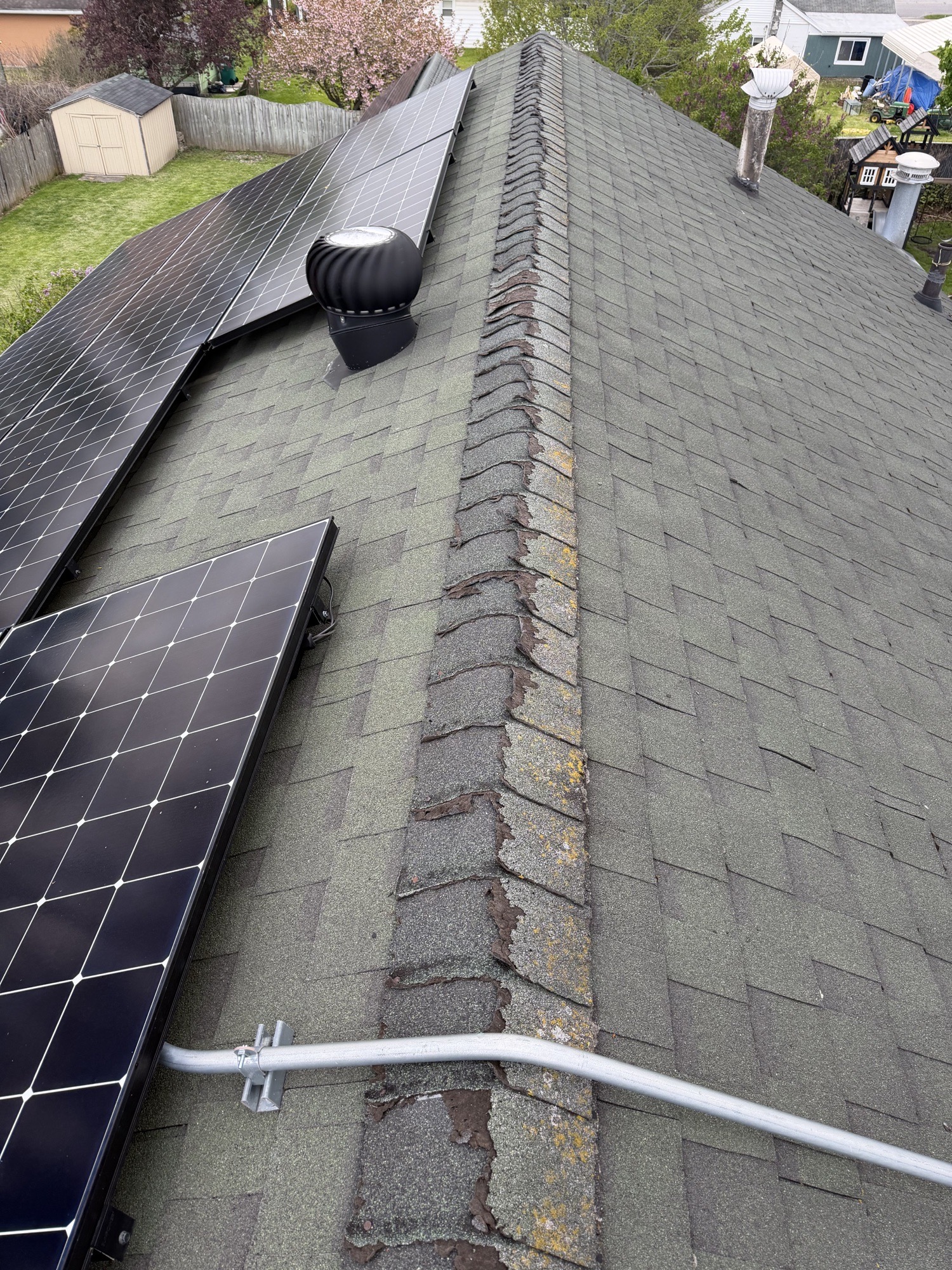 Worn ridge-cap shingles before repair in Batavia