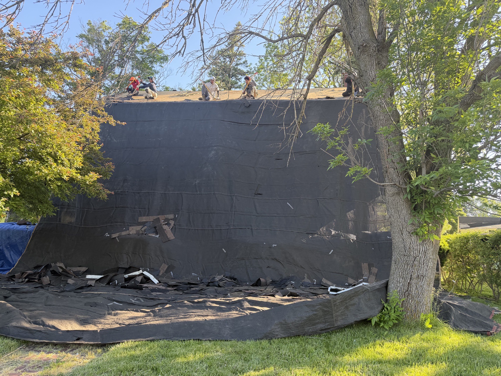 Top Roof crew removing old asphalt roofing from a Batavia home