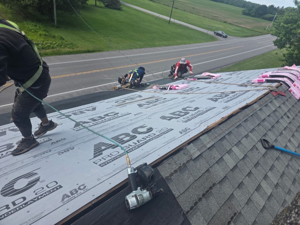 Top Roof crew installing synthetic roof underlayment in Batavia, NY