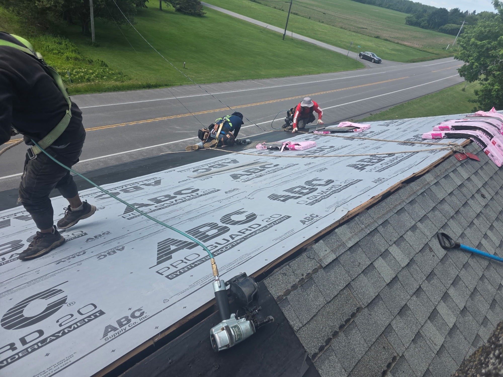 Top Roof crew installing synthetic roof underlayment in Batavia, NY